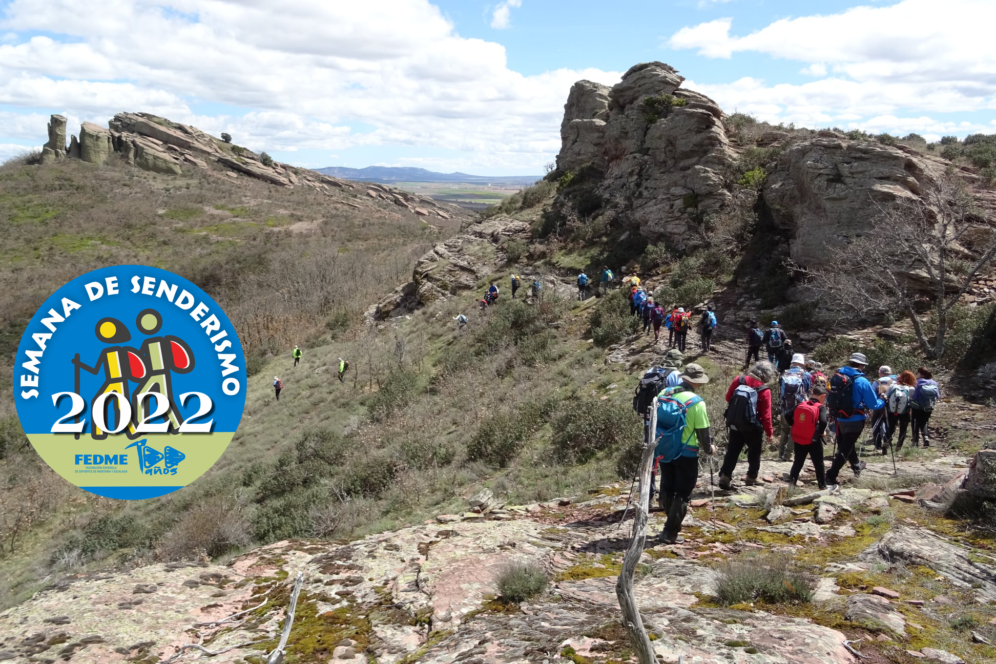 Foto de portada Fotografía en color que presenta a un grupo de senderistas del club Montañeros de Aragón de Zaragoza caminando en el entorno de la Sierra de Lituero. En la parte de la izquierda el logotipo de la Semana de Senderismo 2022