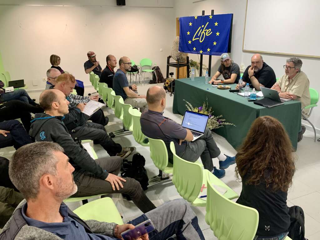 Interior de la sala donde se celebró la jornada. En la mesa de bienvenida se encuentran, el responsable del área de Medio Ambiente FEDME, el Director Conservador del Parque Regional Sierra de Gredos y el Delegado Provincial de la Federación de Montañismo de Castilla y León