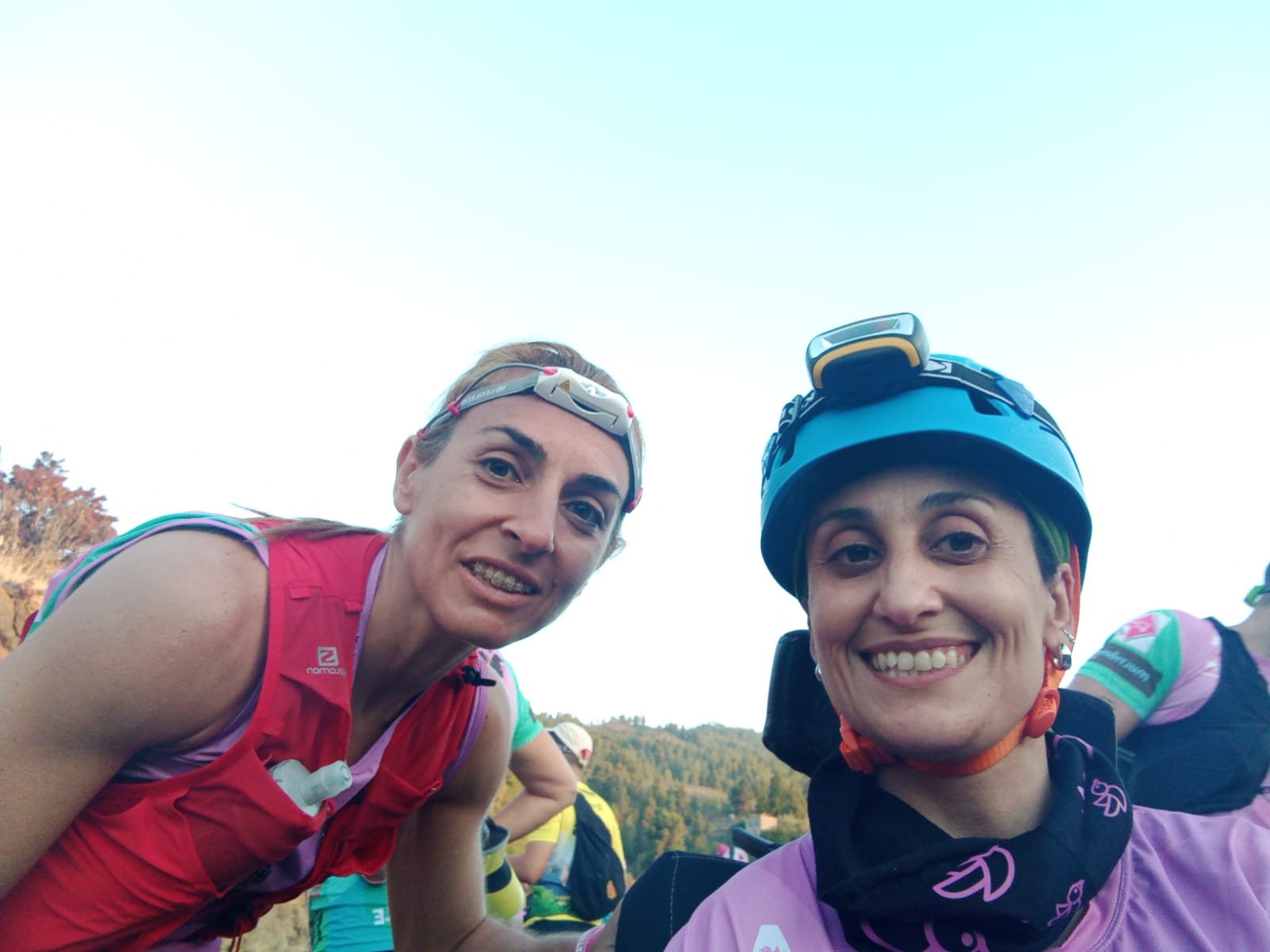 Foto de portada. Primer plano de Isabel Elvira en la silla joëlette y a su lado su guía. Ambas muy sonrientes y equipadas con linternas frontales. Isabel lleva además un casco deportivo.