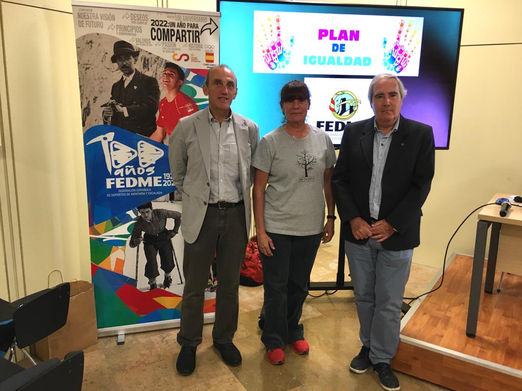 Foto de la portada: De izquierda a derecha aparecen: Alberto Ayora Hirsch Presidente de la FEDME, Reyes de Miguel Renedo Vocal de Igualdad y Responsable del Área de Mujer y Montaña y José María Nasarre Sarmiento Vicepresidente de la FEDME. De fondo pueden verse: el roll up del Centenario Fedme y al lado pantalla con imagen del Plan de Igualdad