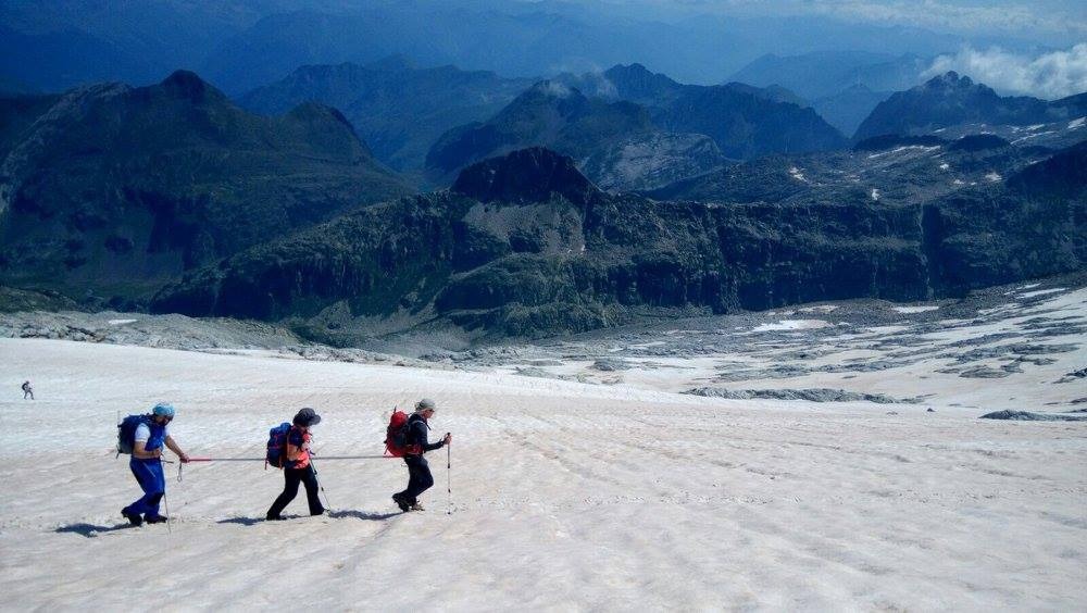 Descripción de la foto de portada: Se ve una ladera nevada por la que ascienden Mayte Minaya entre dos guías utilizando la barra direccional. Se trata de una foto tomada durante su ascensión al Aneto en Pirineos.