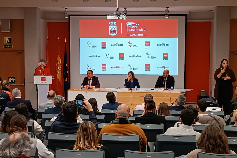 Foto de la mesa de presentación del acto en el Auditorio de la Consejería de Cultura, Turismo y Deporte de la Comunidad de Madrid.. De izquierda a derecha, la yudoca paralímpica Marta Arce; el presidente del Comité Paralímpico Español, Miguel Carballeda; la consejera de Cultura, Turismo y Deporte de la Comunidad de Madrid, y el presidente de la Federación Madrileña de Deportes para Personas con Discapacidad Física, José Criado. En primer plano, de espaldas, algunos de los asistentes al acto.