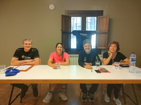 Cuatro de los responsables del evento sentados en una mesa sonriendo a la camara.