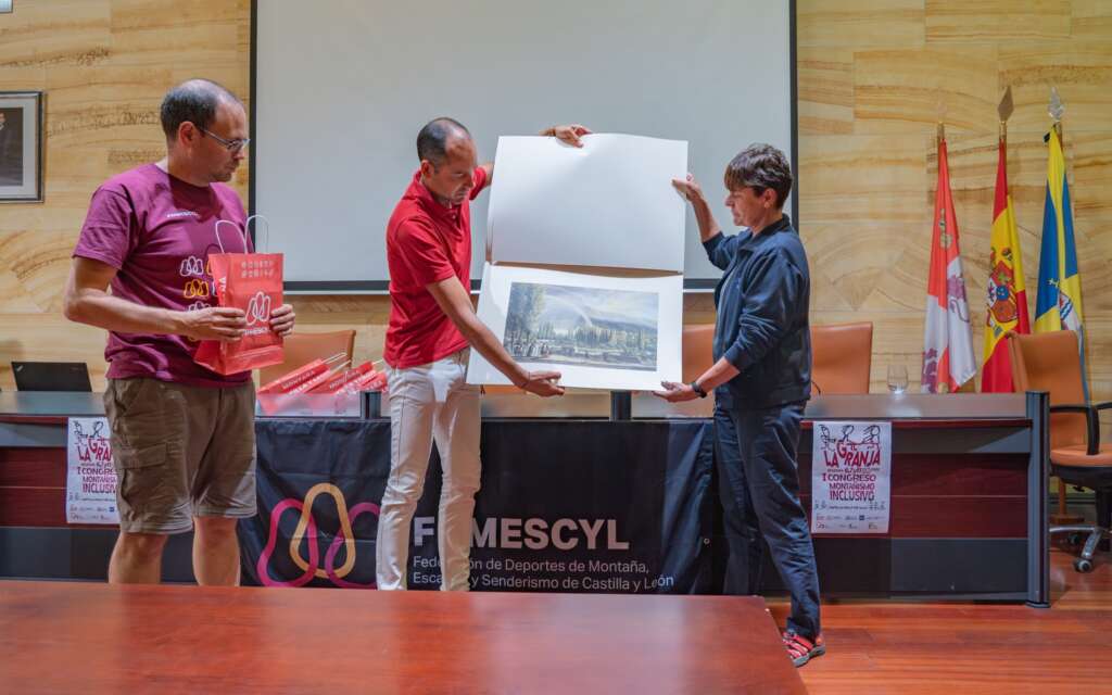 20. Imagen de la clausura, Samuel Alonso y Reyes de Miguel muestran al público lámina fotográfica de los Jardines de La Granja que entrega a FDMESCYL y a la FEDME