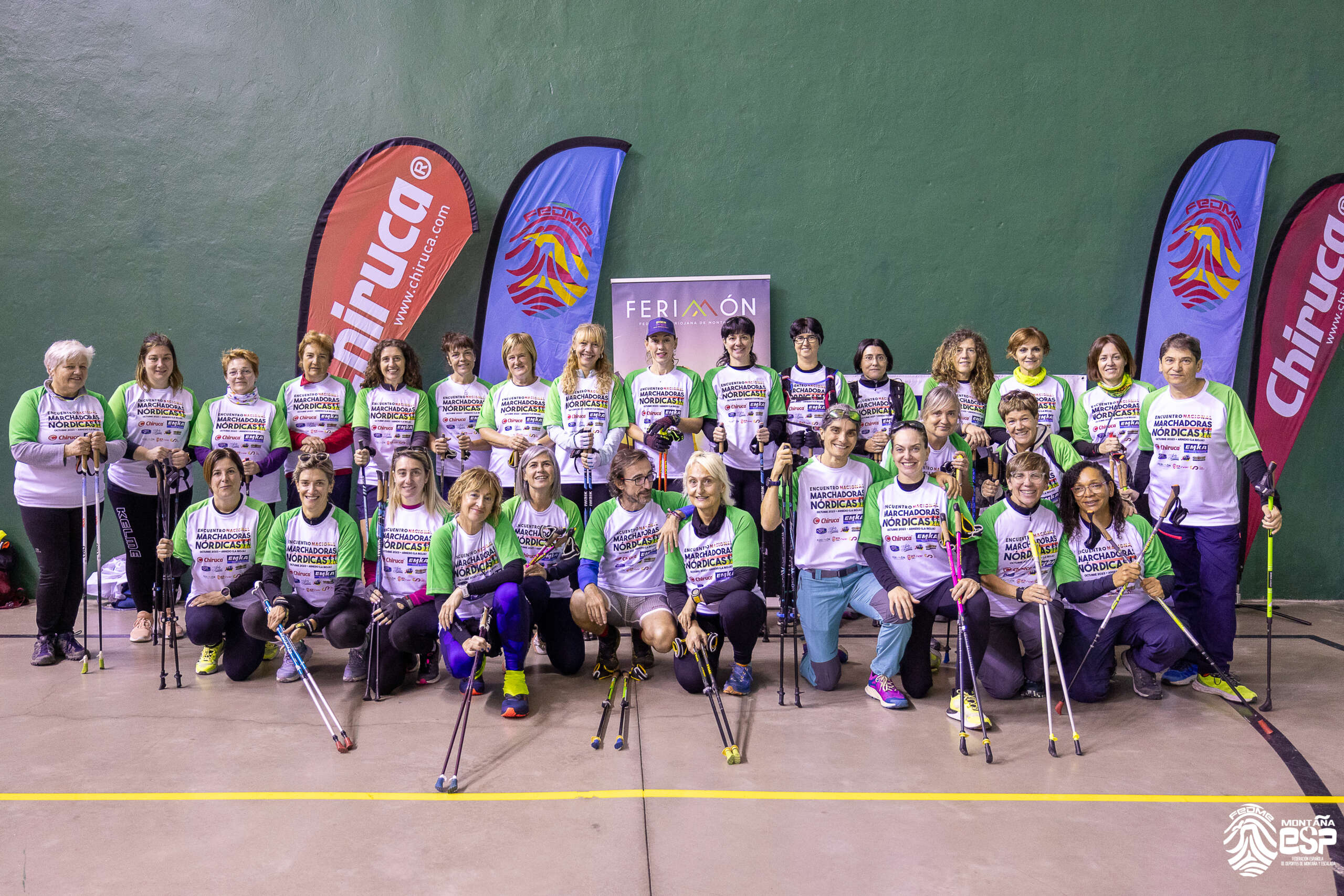 Aparecen todas las mujeres participantes al Encuentro nacional de marchadoras nórdicas, unas de pie y delante otras en cuclillas. Todas ellas con camiseta del evento y bastones