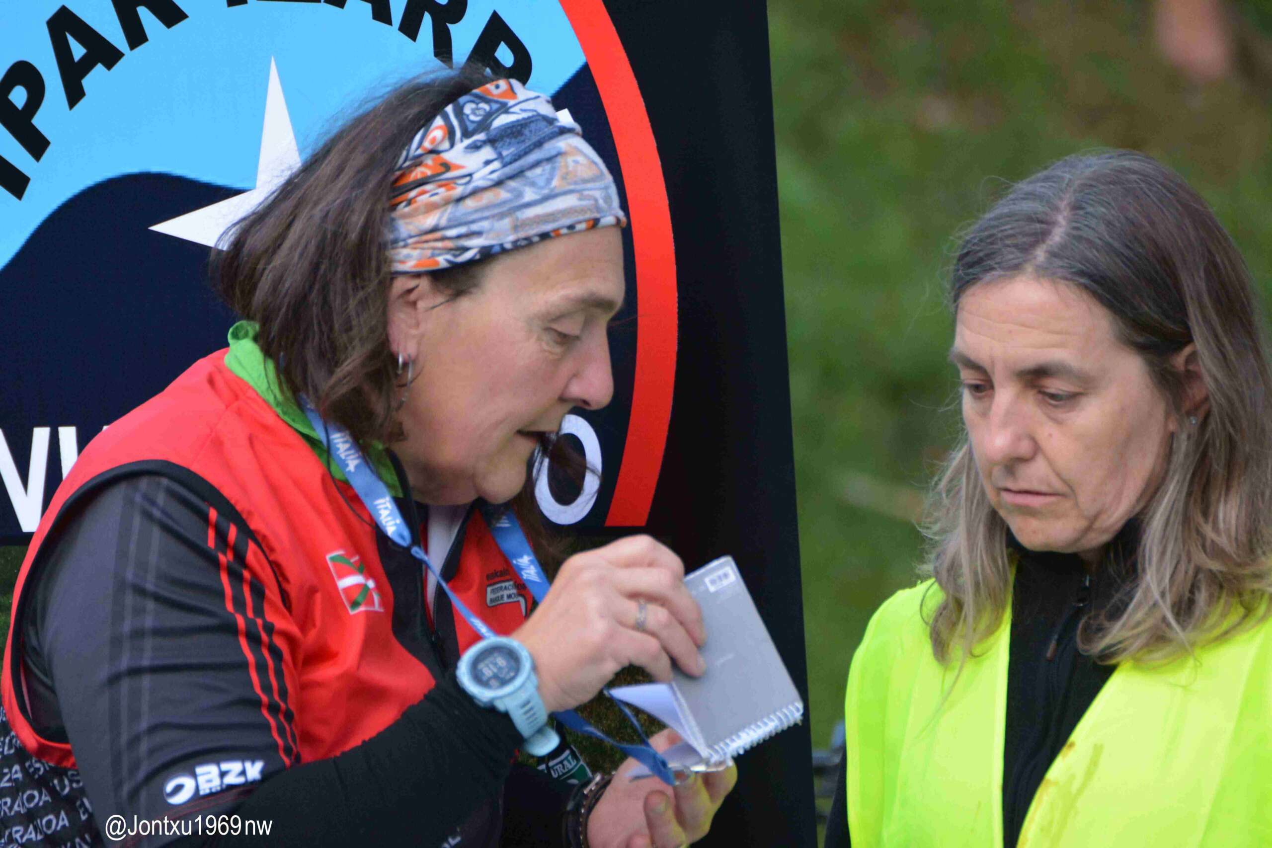 Primer plano en el que aparecen Gema y su compañera árbitra en prácticas Usue Santxo en el II Campeonato de Euskadi en Gorliz (Bizkaia) preparando el material de arbitraje con la libreta donde apuntan las amonestaciones durante la competición en la mano.